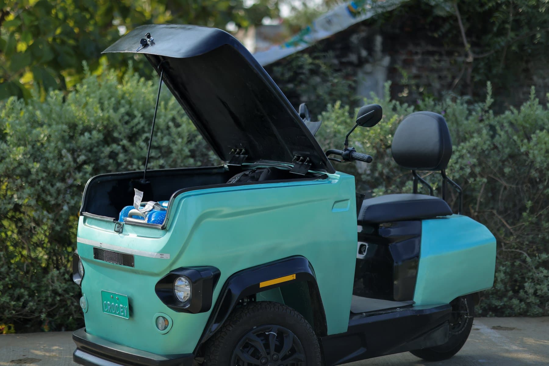 A teal CROC EV with its front cargo box open