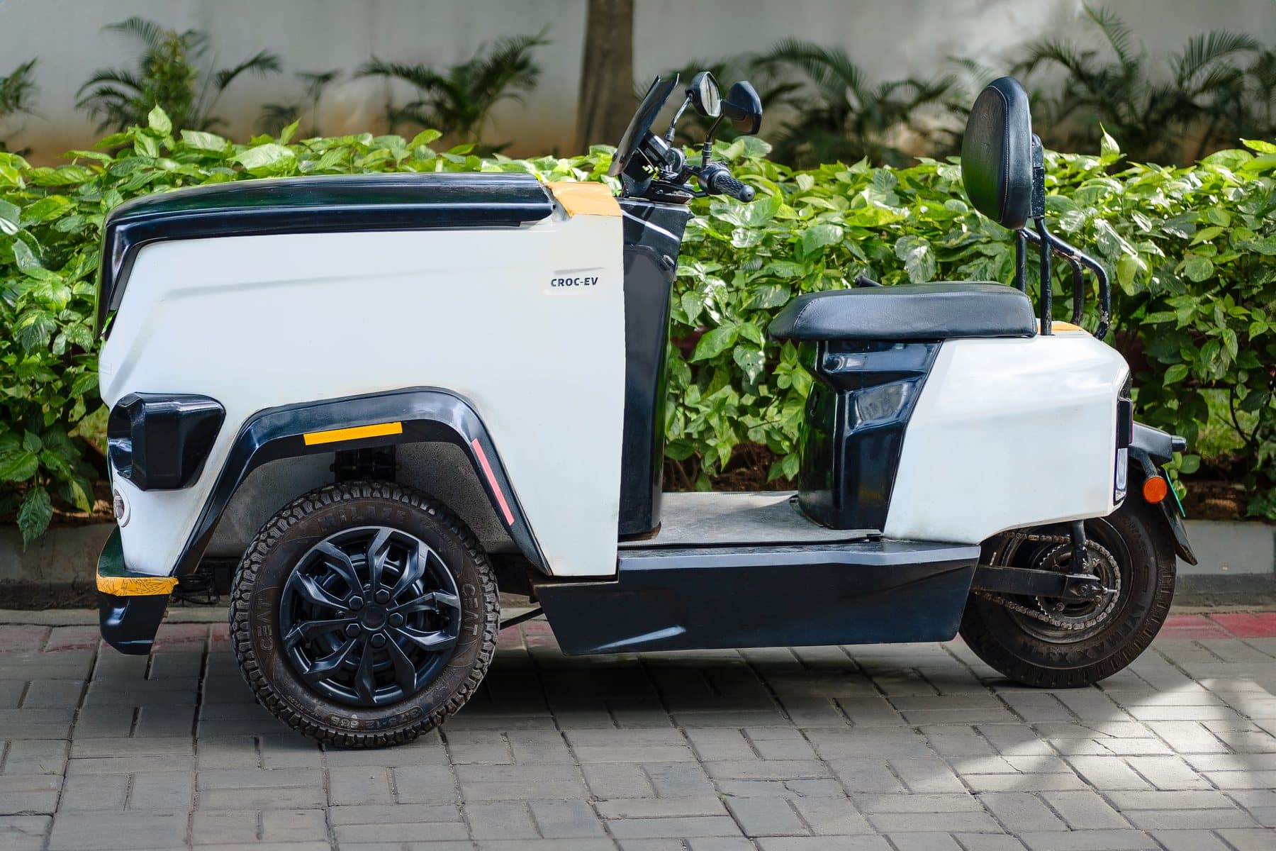 A white CROC EV parked on paving, photographed from the side